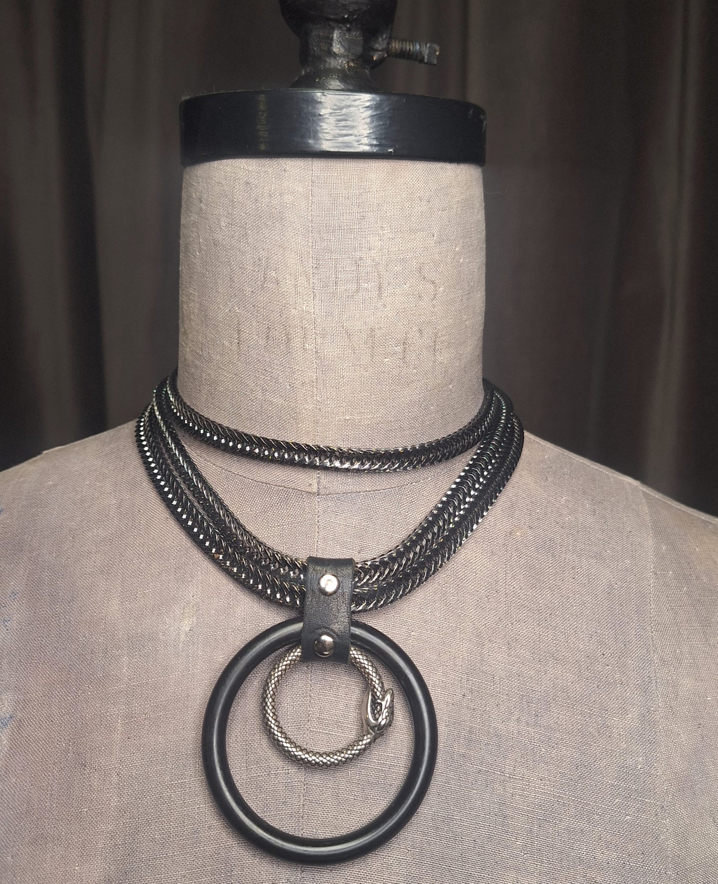 The Python. Flat Franco, gunmetal chain with 2" black O-ring and brushed silver Ouroboro. The chain wraps around the neck through the leather connector and can be worn several ways. Handmade.