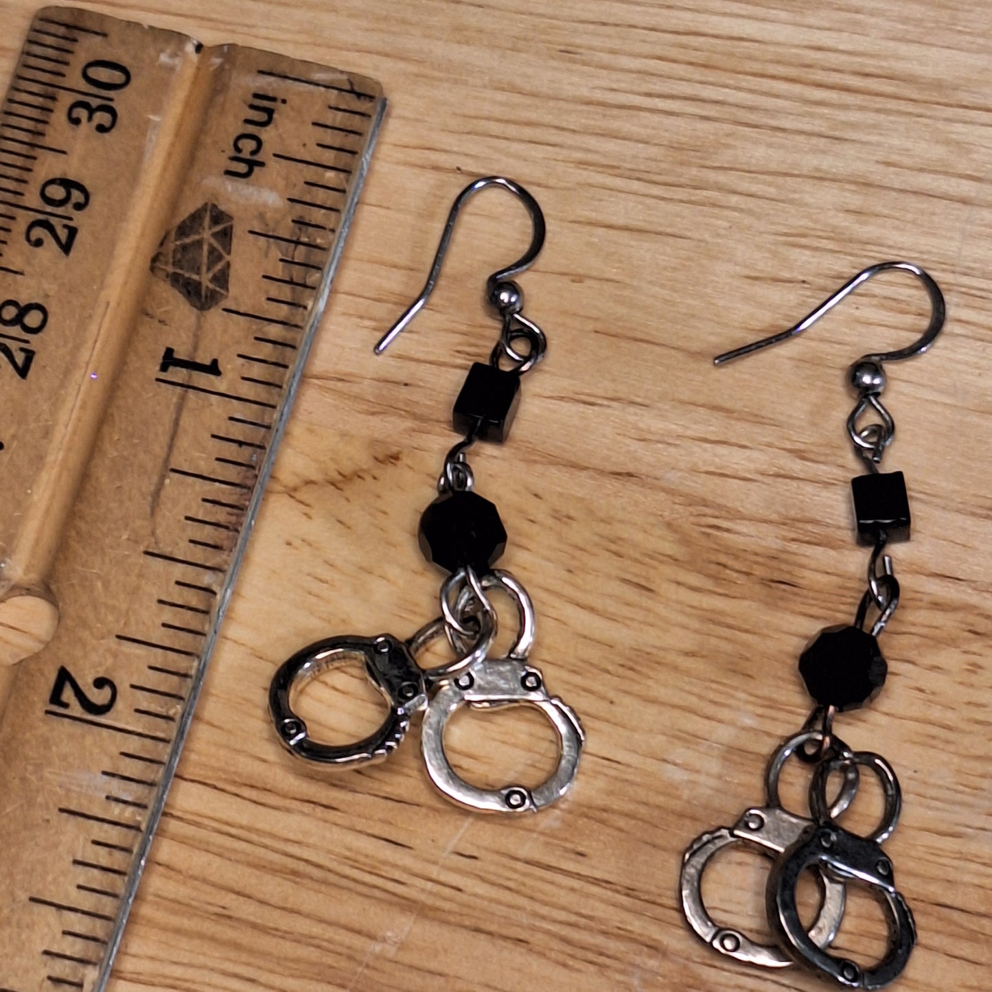 The Misdemeanor. Silver handcuff and black bead dangle earrings. Ear hooks.