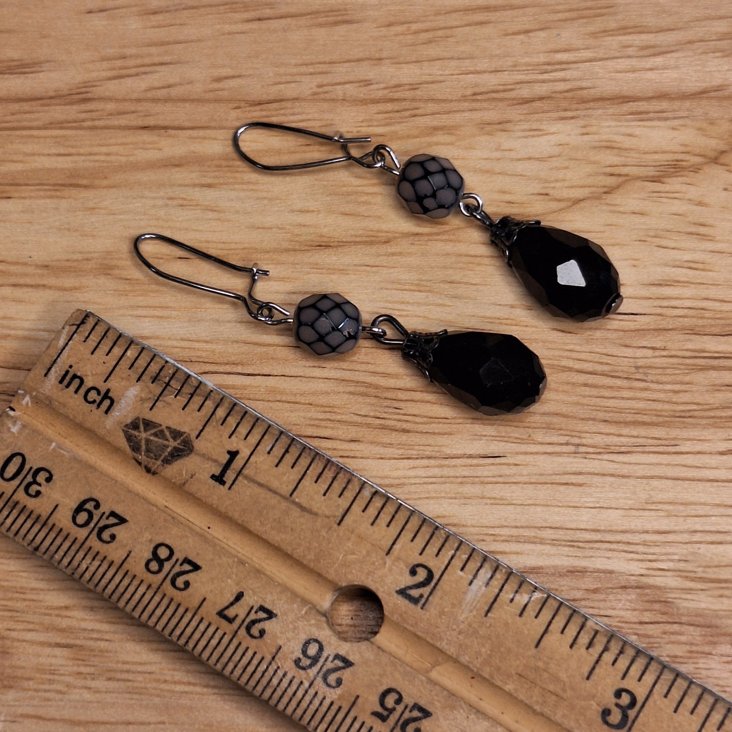 Black crystal teardrop and lavender faceted glass drop earrings. Silver hook closure.