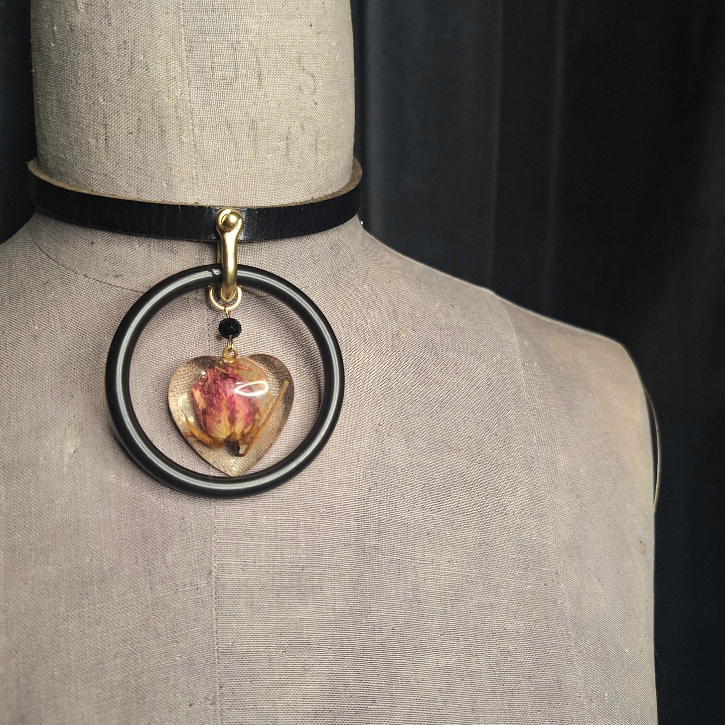 The Deadly Rose. Chic leather necklace with a single pink dried rosebud in a resin heart pendant.