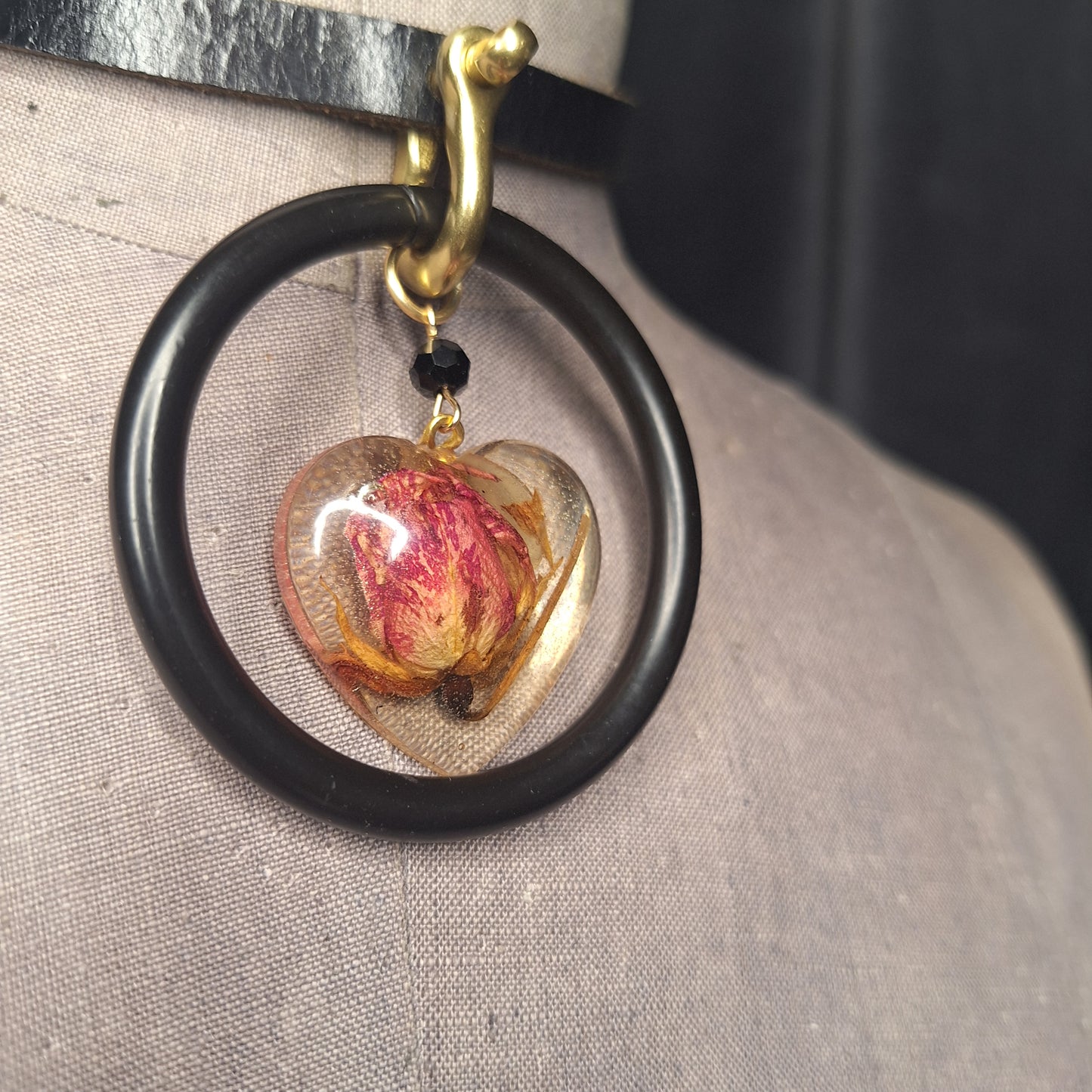 The Deadly Rose. Chic leather necklace with a single pink dried rosebud in a resin heart pendant.