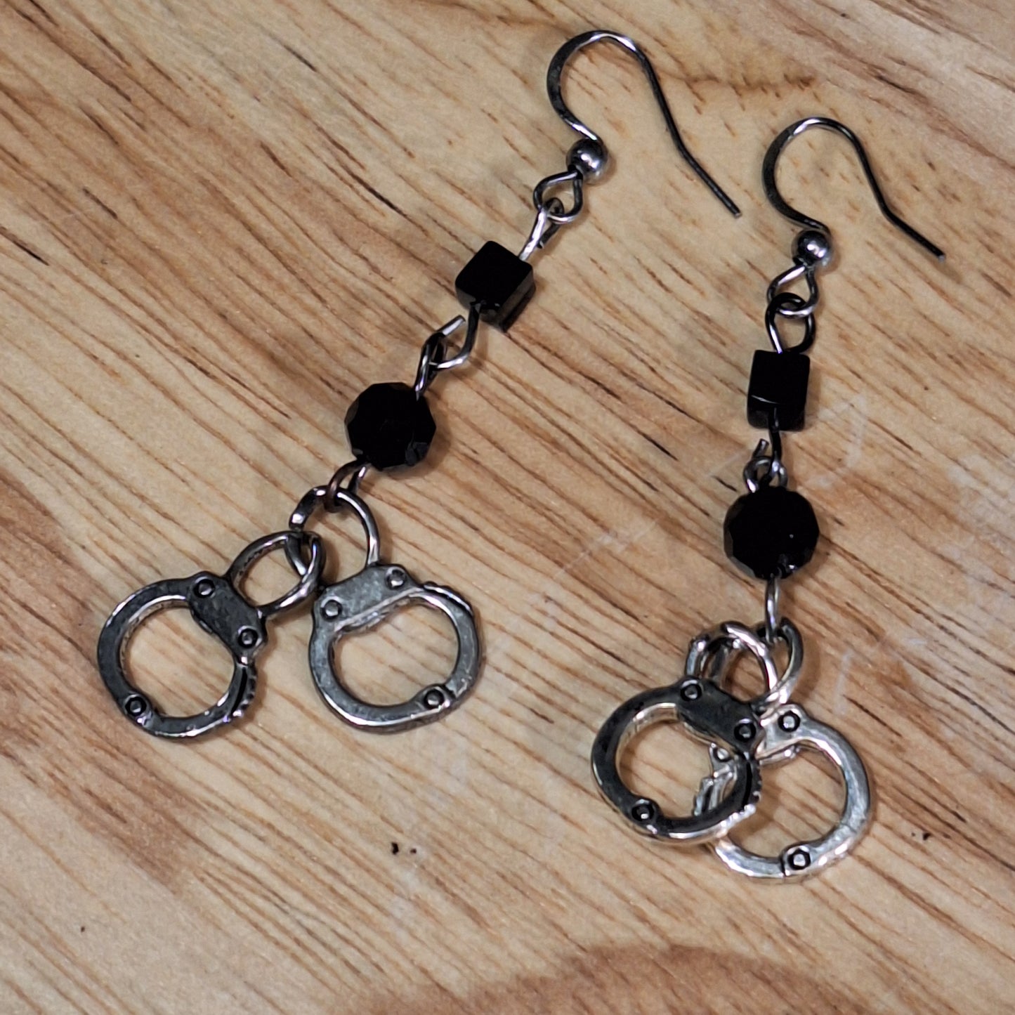 The Misdemeanor.  Silver handcuff and black bead dangle earrings. Ear hooks.