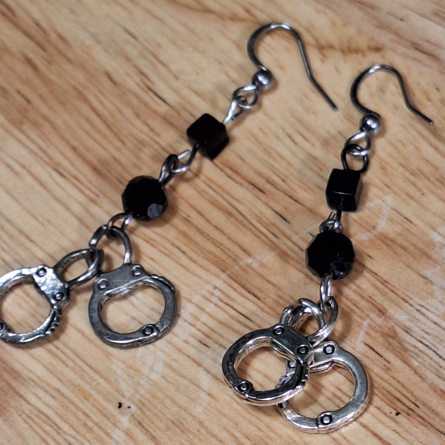 The Misdemeanor.  Silver handcuff and black bead dangle earrings. Ear hooks.