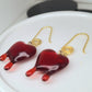 Red dripping heart and gold swirl hook earrings.