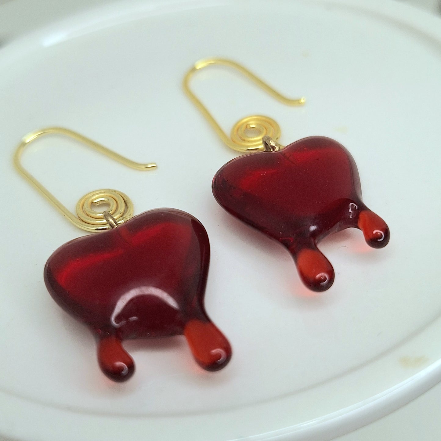 Red dripping heart and gold swirl hook earrings.