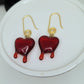 Red dripping heart and gold swirl hook earrings.