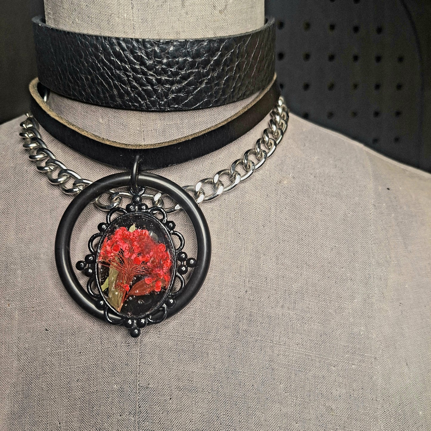 The Fire Starter. Spark your dark fem fire with this One-of-a-kind pressed flower pendant choker. Suspended in a black steel oring, off a chic black leather strip of leather. Layer it up, layer it down.