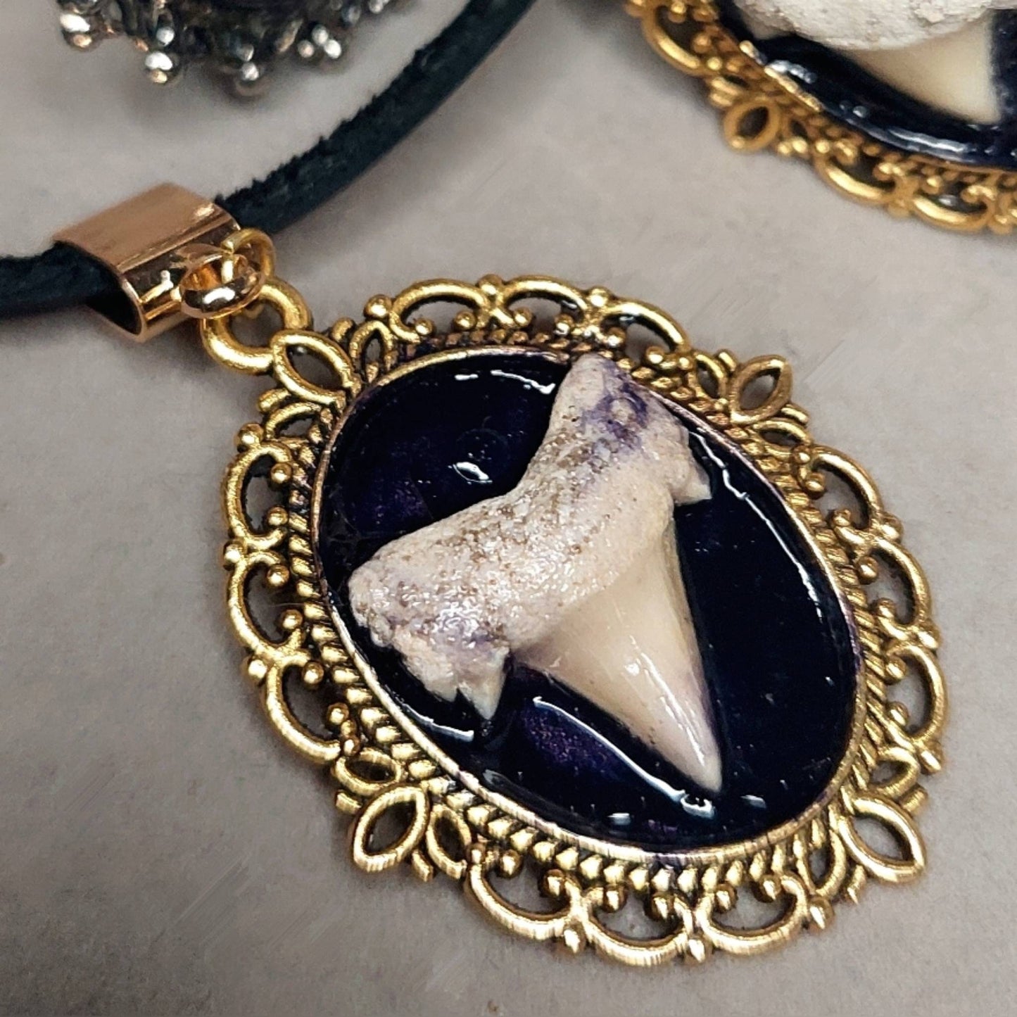 Tooth adornment in ornate gold frame.