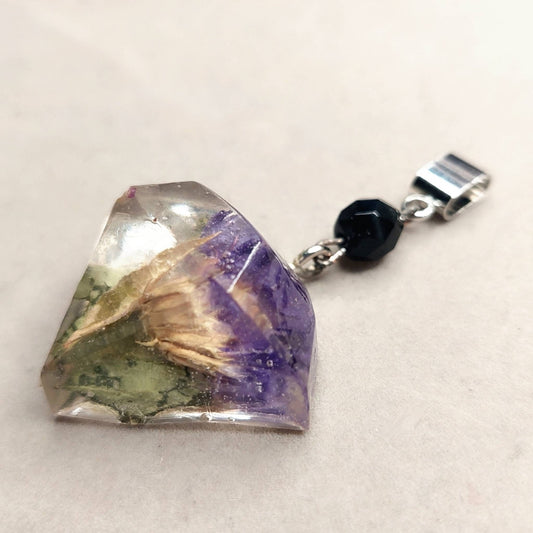 Jewel cut cast resin pendant with purple flowers.